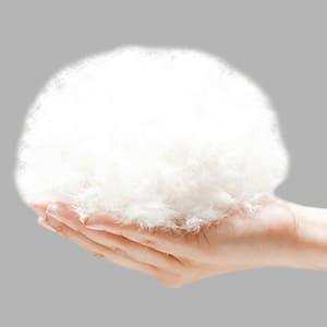 Hand holding soft white cotton fluff against a plain gray background